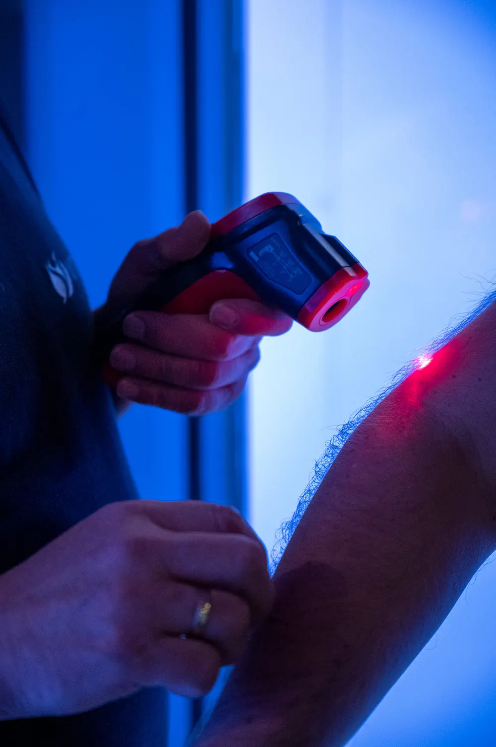 Mitarbeiter misst nach dem Gang die Hauttemperatur am Arm